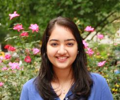 Sweta standing in front of flowers