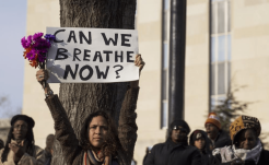 Person holding up a sign that says "Can we breathe now?"