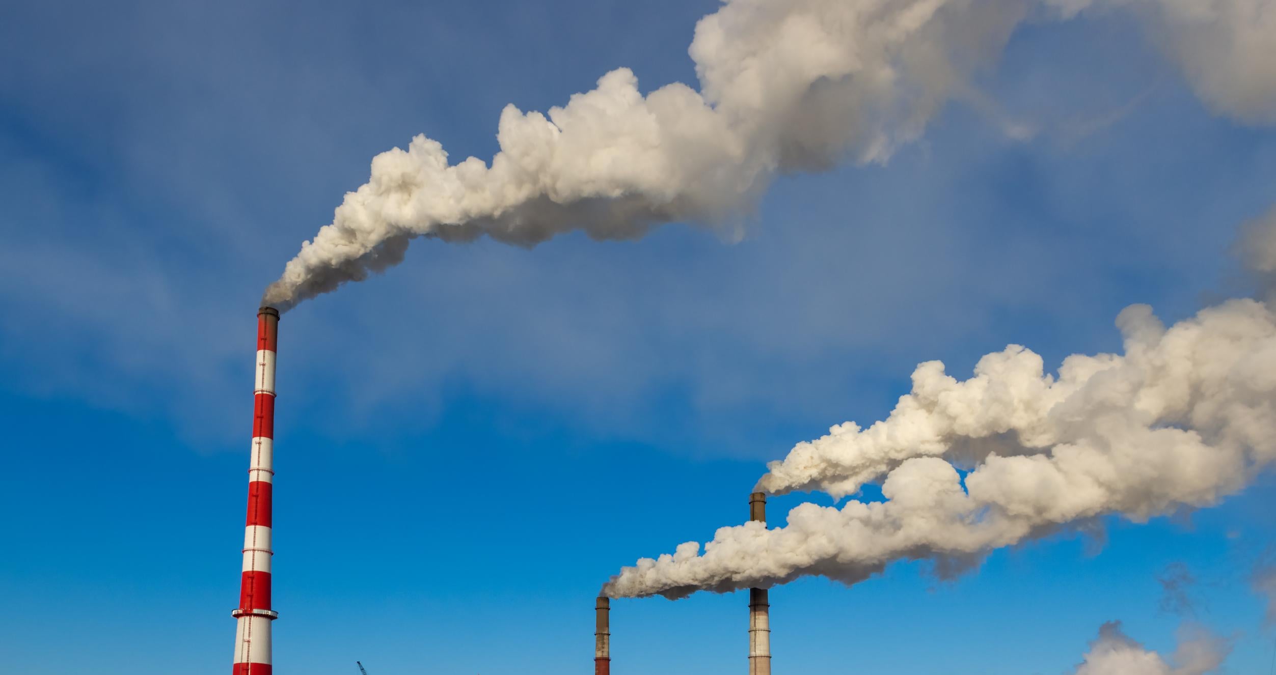 Smoke from the pipes in the factory into the atmosphere.