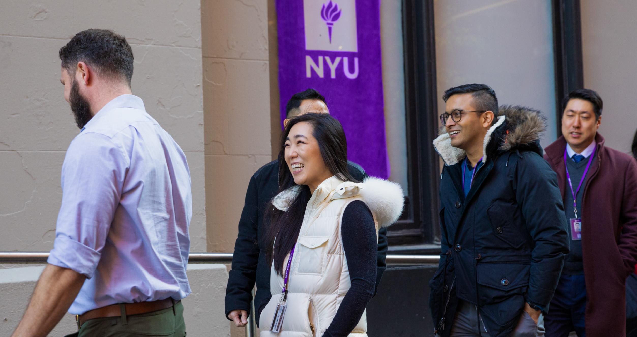 Executive MBA students with an NYU flag