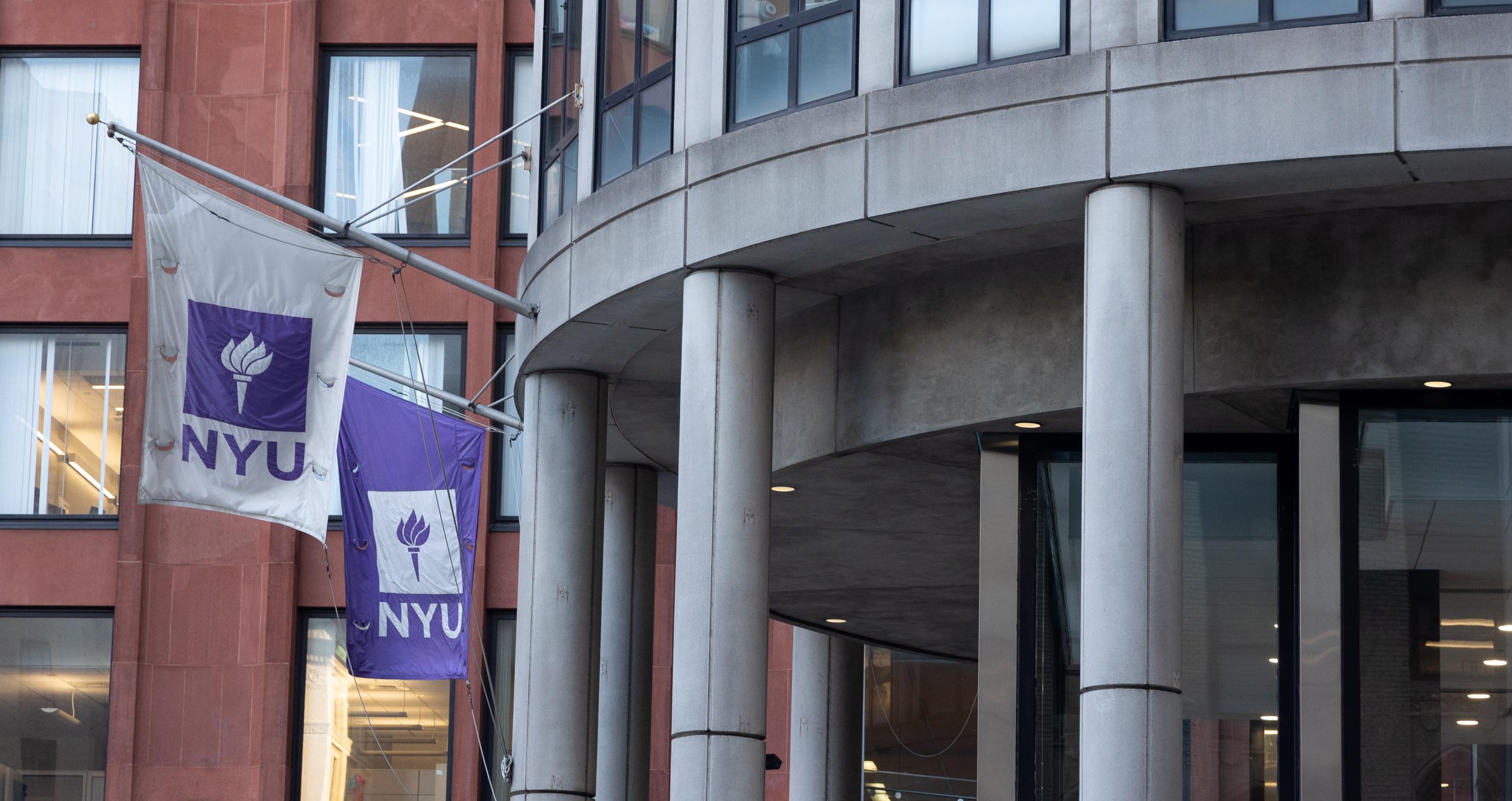 NYU flags fly above entrance to NYU Stern.