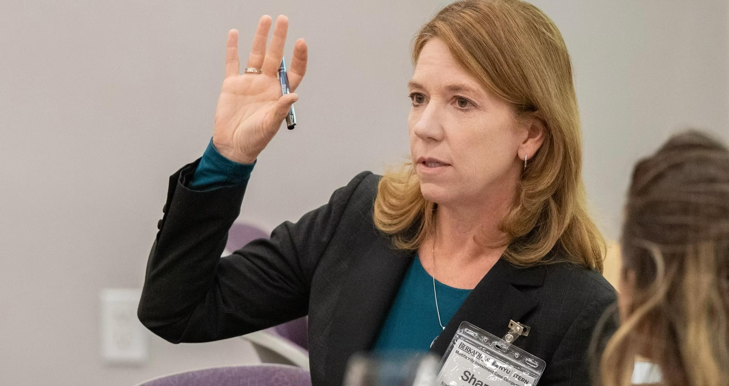 Participant stands with raised hand to ask a question
