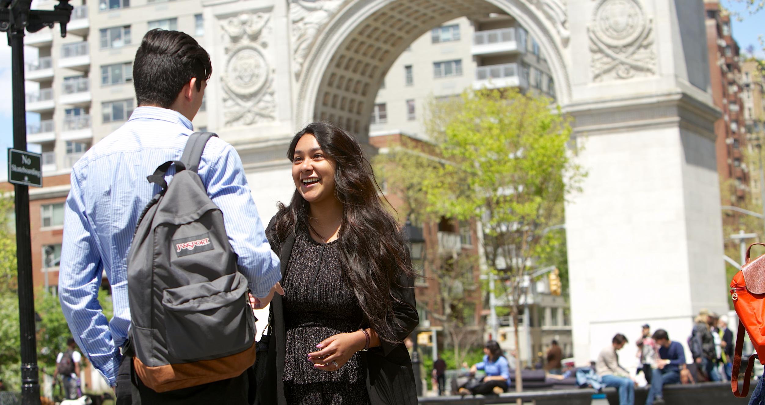 Students chat in front of the arch at Washington Square Park