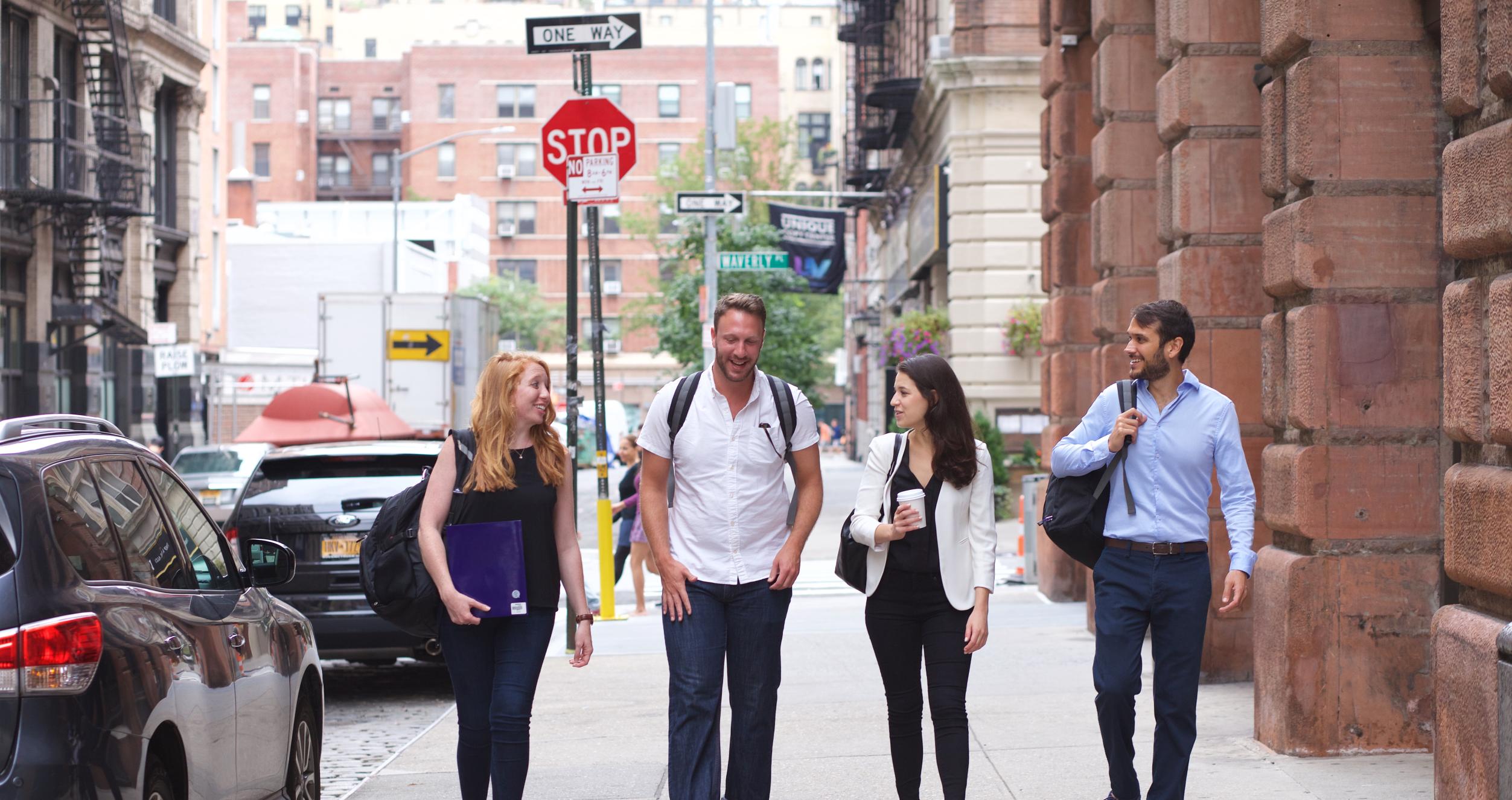 Four people walking down the street Four people walking down the street