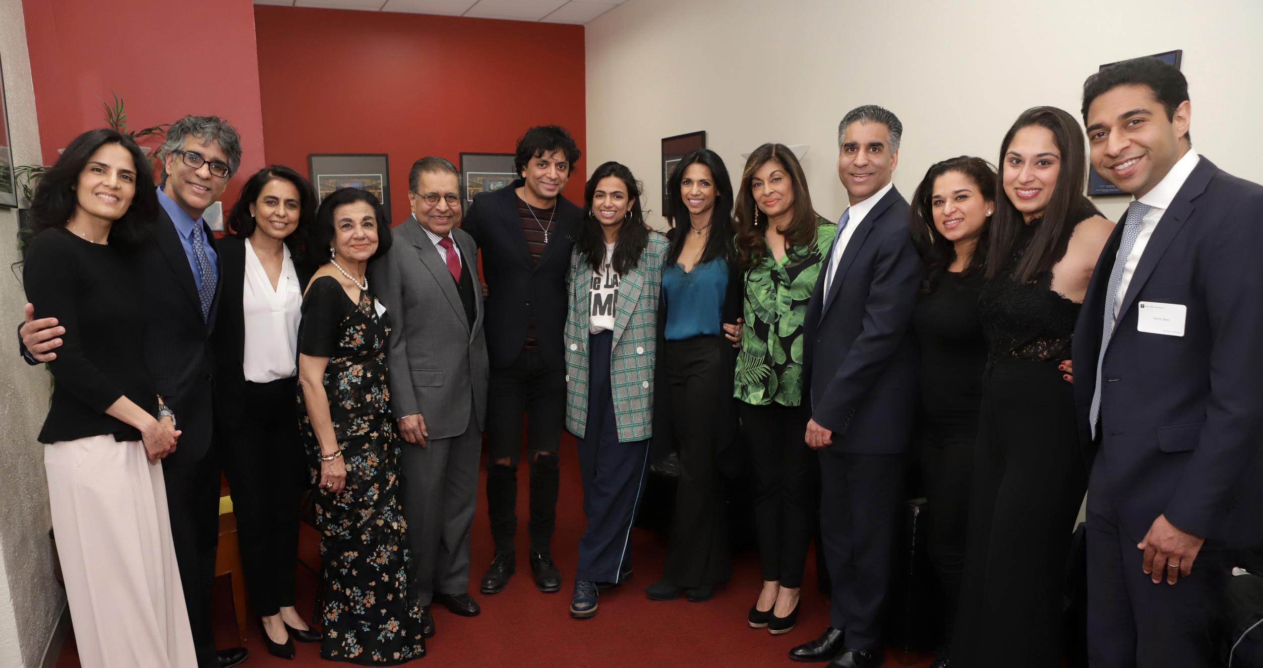 A large group of people posing for a photo in red room