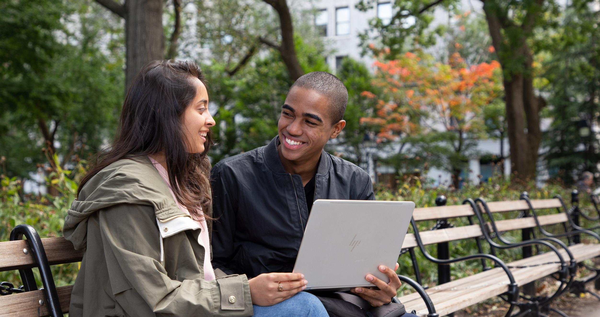 Stern students sit on a bench with a laptop Stern students sit on a bench with a laptop