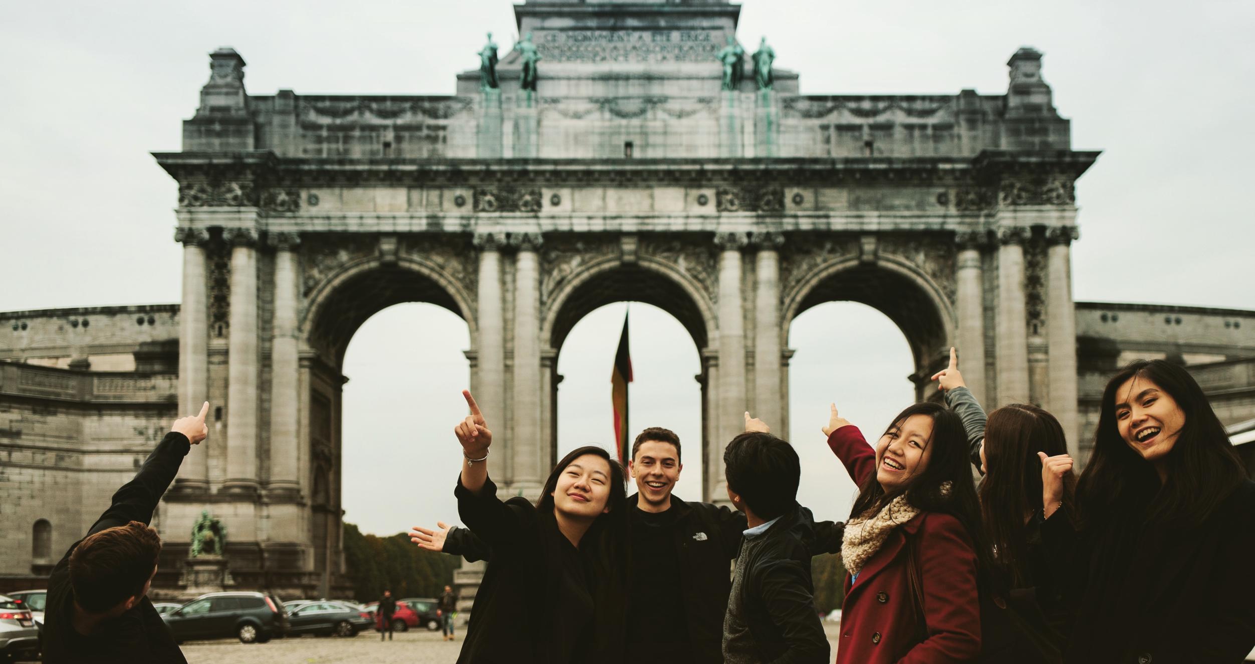 Students pointing to the Arcade du Cinquantenaire on their Brussels, Belgium trip during their semester abroad