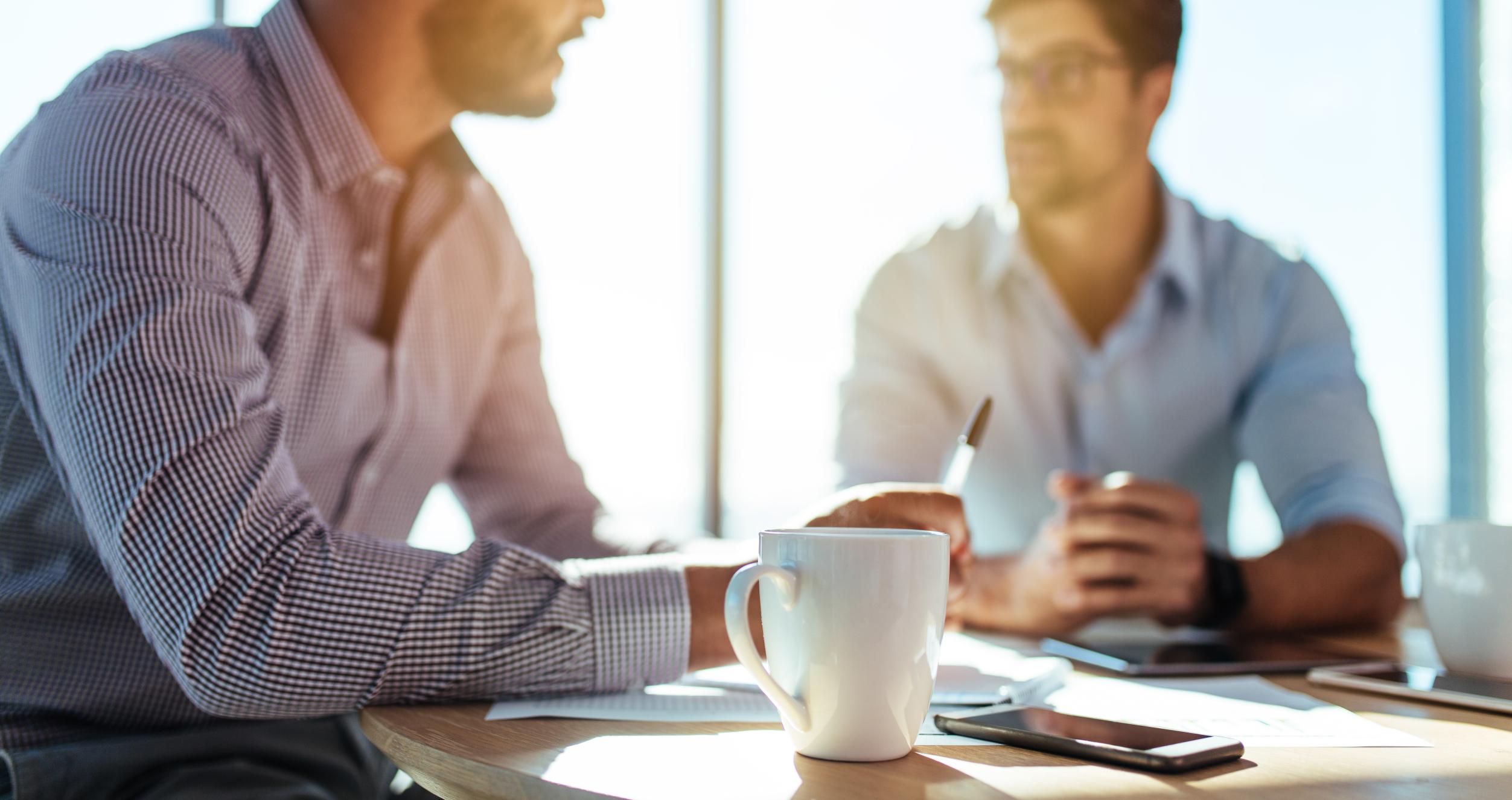 Two men having coffee and chatting 