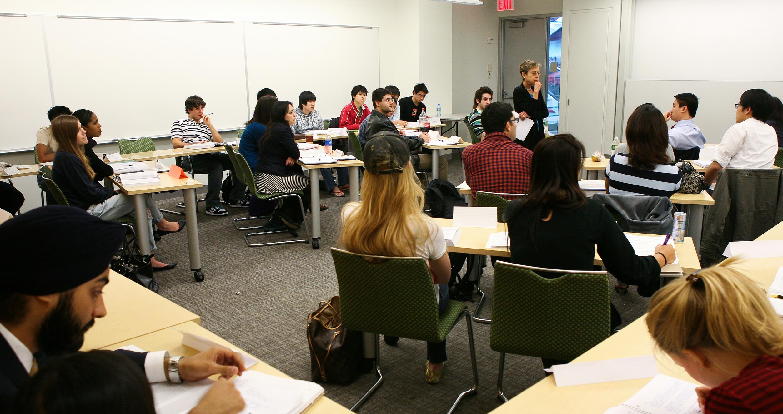 An NYU Stern professor teaches a small classroom of business students
