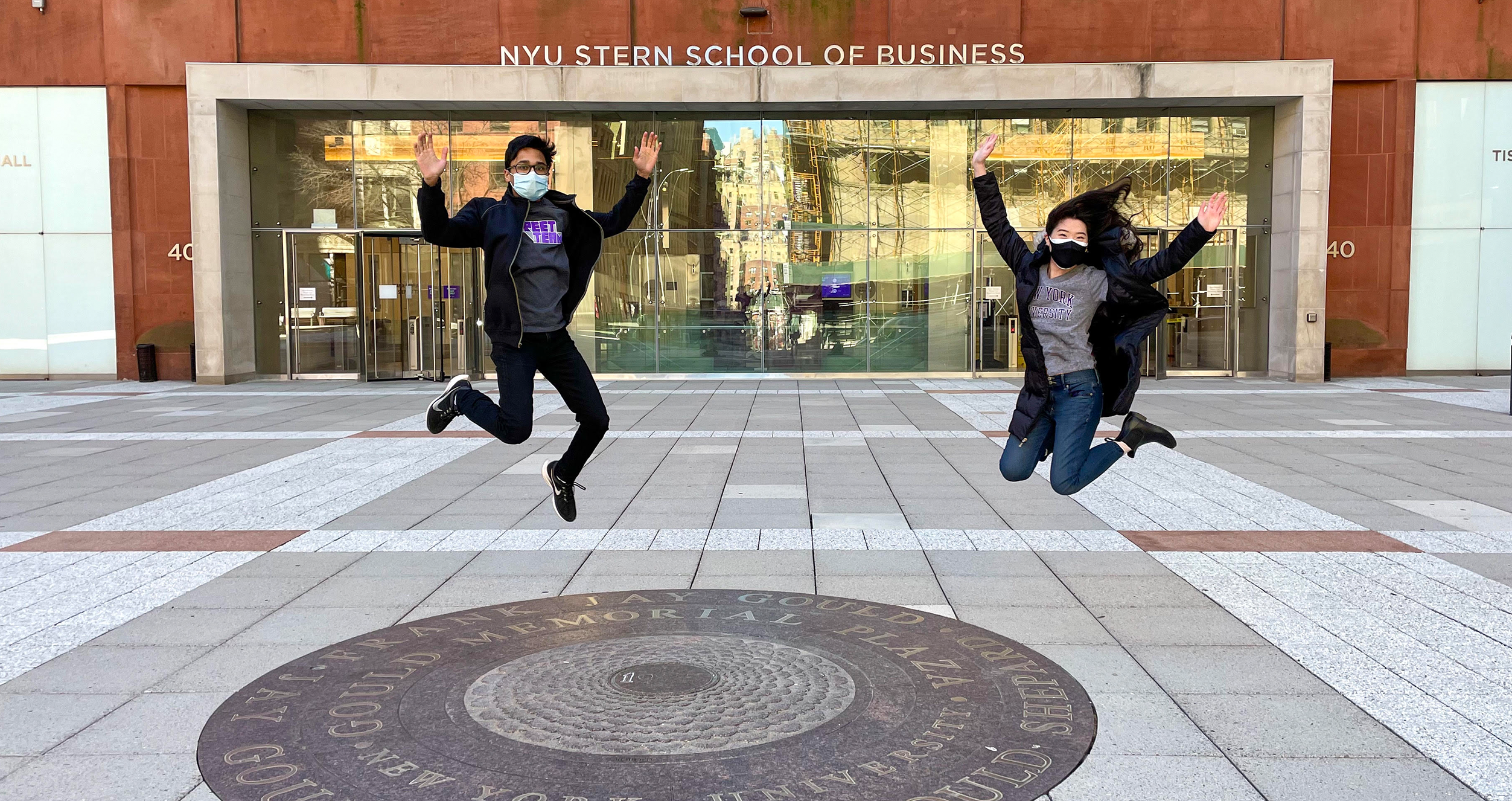 Students jumping up in front of Tisch Hall