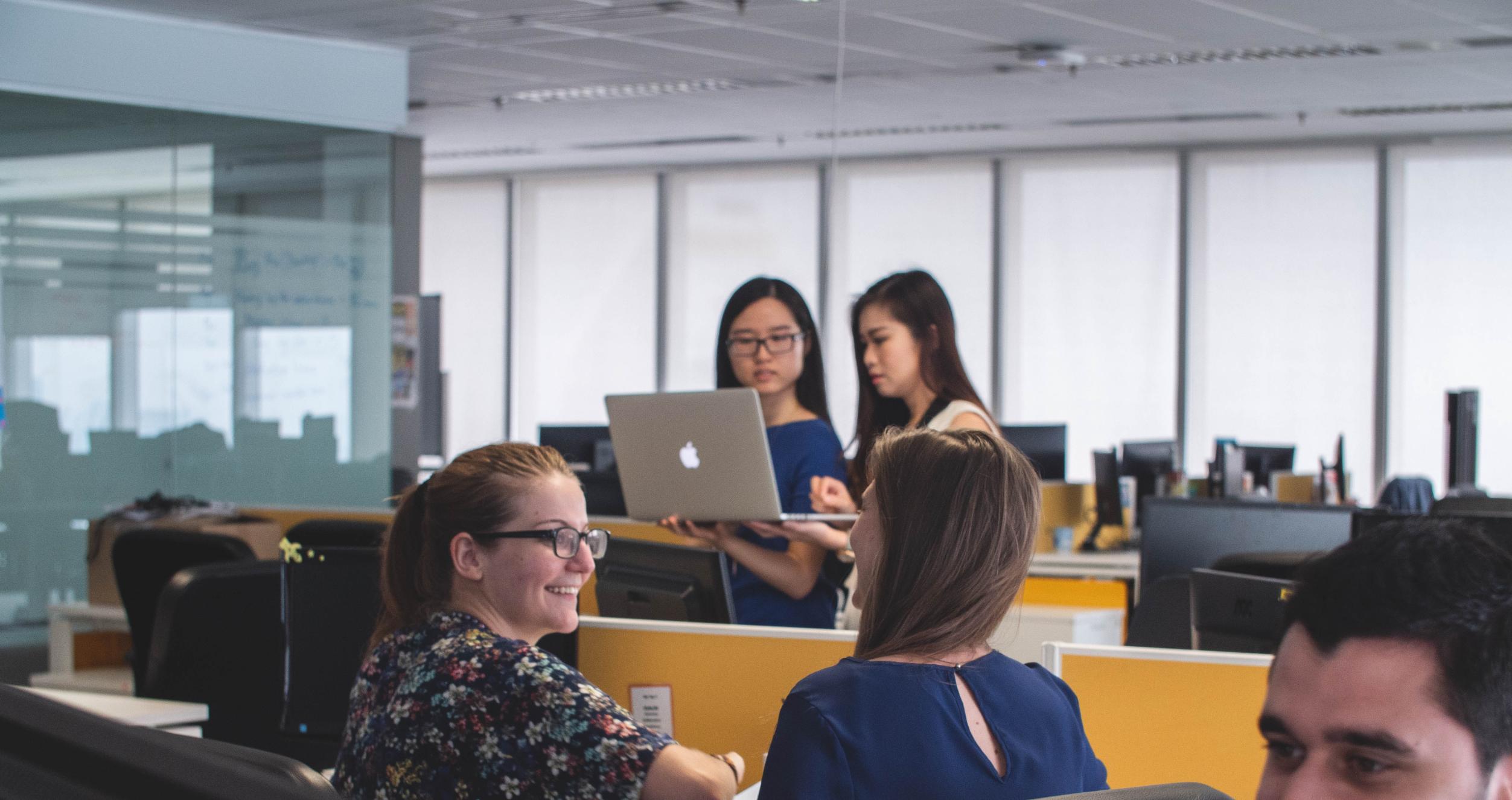 Men and women working in the an open office setting