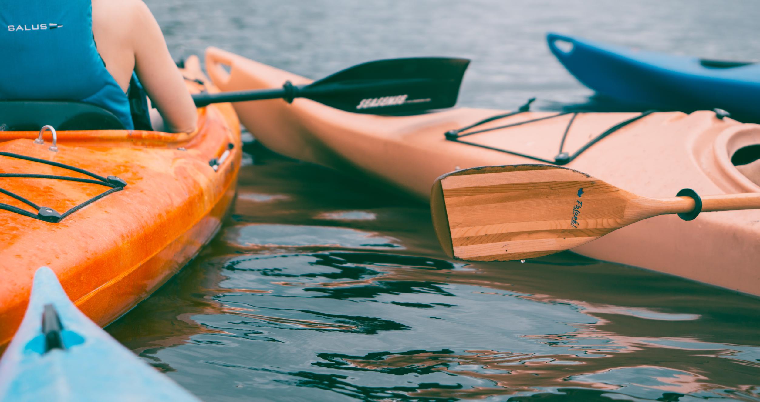 Person riding on orange kayak during daytime