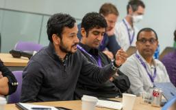 deepak hedge speaking at desk