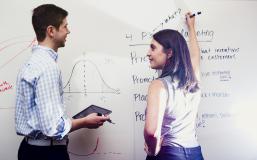 Marketing Alumni Group Students writing about marketing on a white board