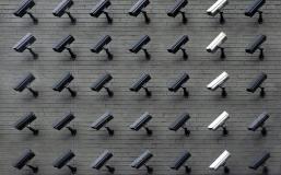 A brick wall filled with security cameras