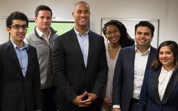 Five students and professor standing in conference room