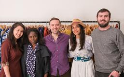 Students standing in front of clothing rack