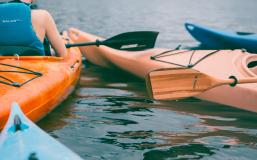 Person riding on orange kayak during daytime