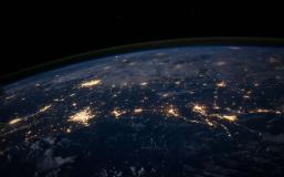Photo of earth from outer space with cities lit up by electrical lights