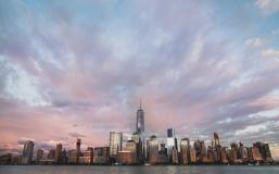 Assorted NYC buildings near body of water under cloudy sky Assorted NYC buildings near body of water under cloudy sky