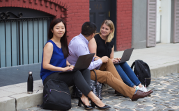 woman on curb with laptop