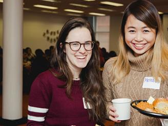 Two student smiling and posing with food