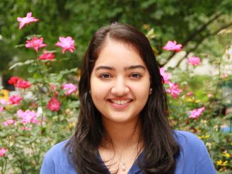 Sweta standing in front of flowers