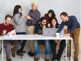 The team from Fairgrade, winners of the New Venture Competition in the 2020 Entrepreneurs Challenge. a group of people at a table collaborating