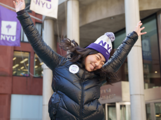 A student in NYU-branded attire celebrates NYU One Day