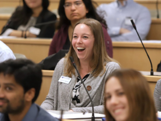 Woman in classroom with other students smiling