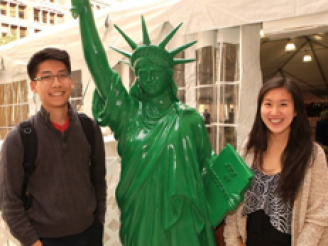 Students next to a replica of Statue of Liberty