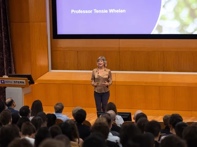 A picture of Professor Tensie Whelan speaking before a crowd in an auditorium 