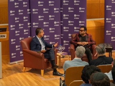 Dean Bharat and A R Rahman sitting in conversation in front of an audience