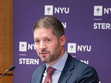 NYU Stern Professor Michael Dickstein speaking at a podium.