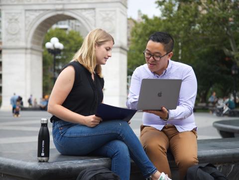 Sternies looking at a laptop in front of the arch