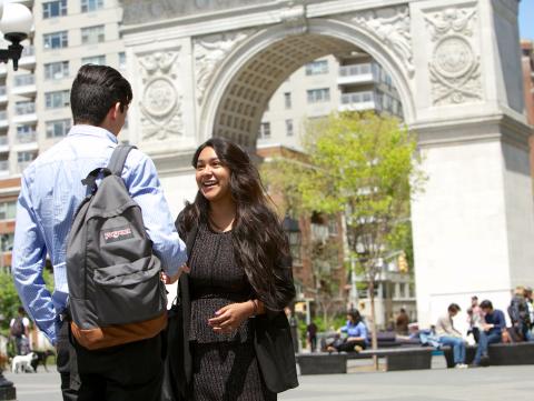 Students chat in front of the arch at Washington Square Park