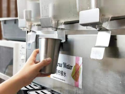 Student refilling steel cup