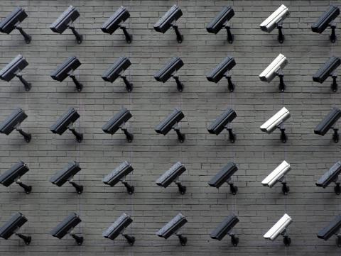 A brick wall filled with security cameras
