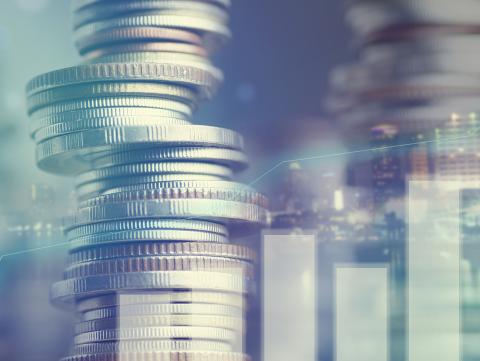 Double exposure of city and graph on rows of coins for finance and banking concept