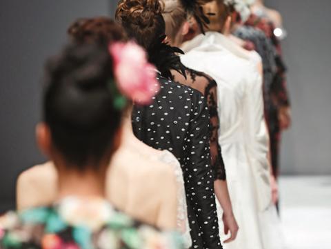 Women in single-file line on a fashion show runway