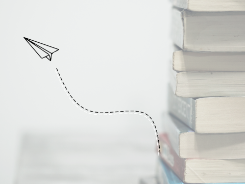 A pile of textbooks with an illustrated paper plane flying away
