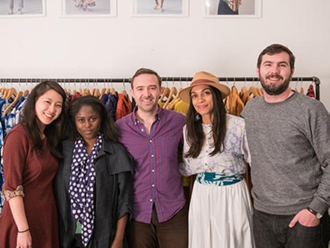 Students standing in front of clothing rack