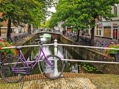 SAW: Netherlands image Image of a bridge with a bike on it and many bikes parked along both sides of the canal in The Netherlands
