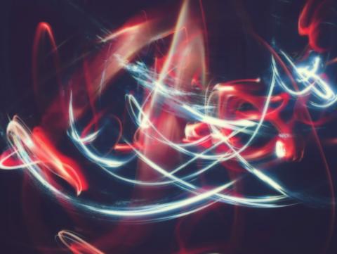 White and red light trails forming abstract patterns in a dark setting