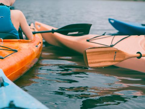 Person riding on orange kayak during daytime