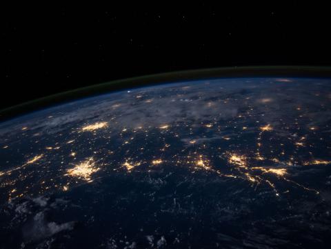 Photo of earth from outer space with cities lit up by electrical lights