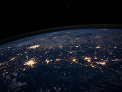 Photo of earth from outer space with cities lit up by electrical lights 