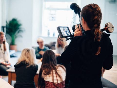 Woman films a group of people talking