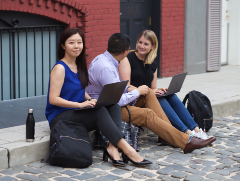 woman on curb with laptop