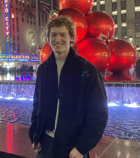 Ben smiling in front of a fountain 